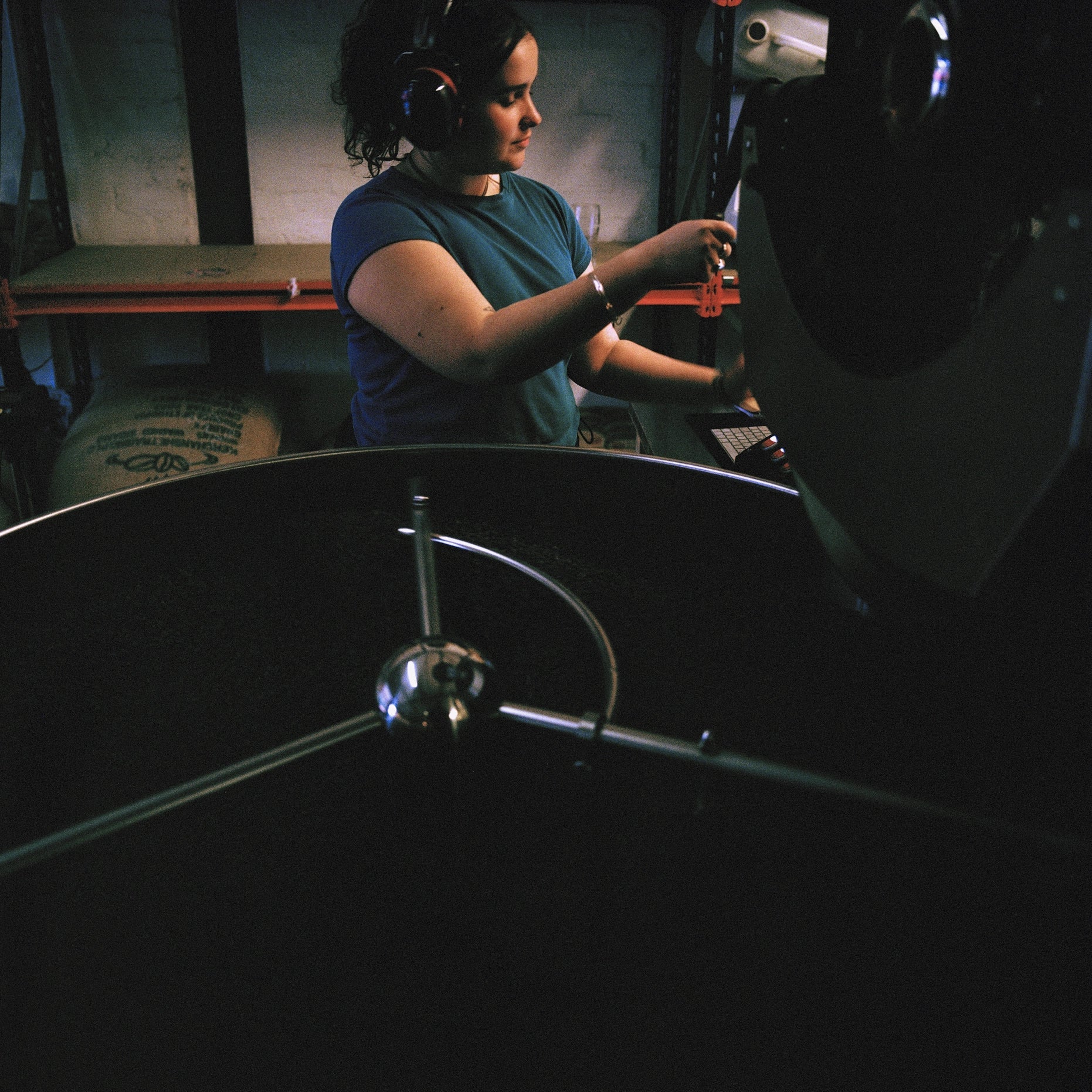 Woman operating a coffee roaster.