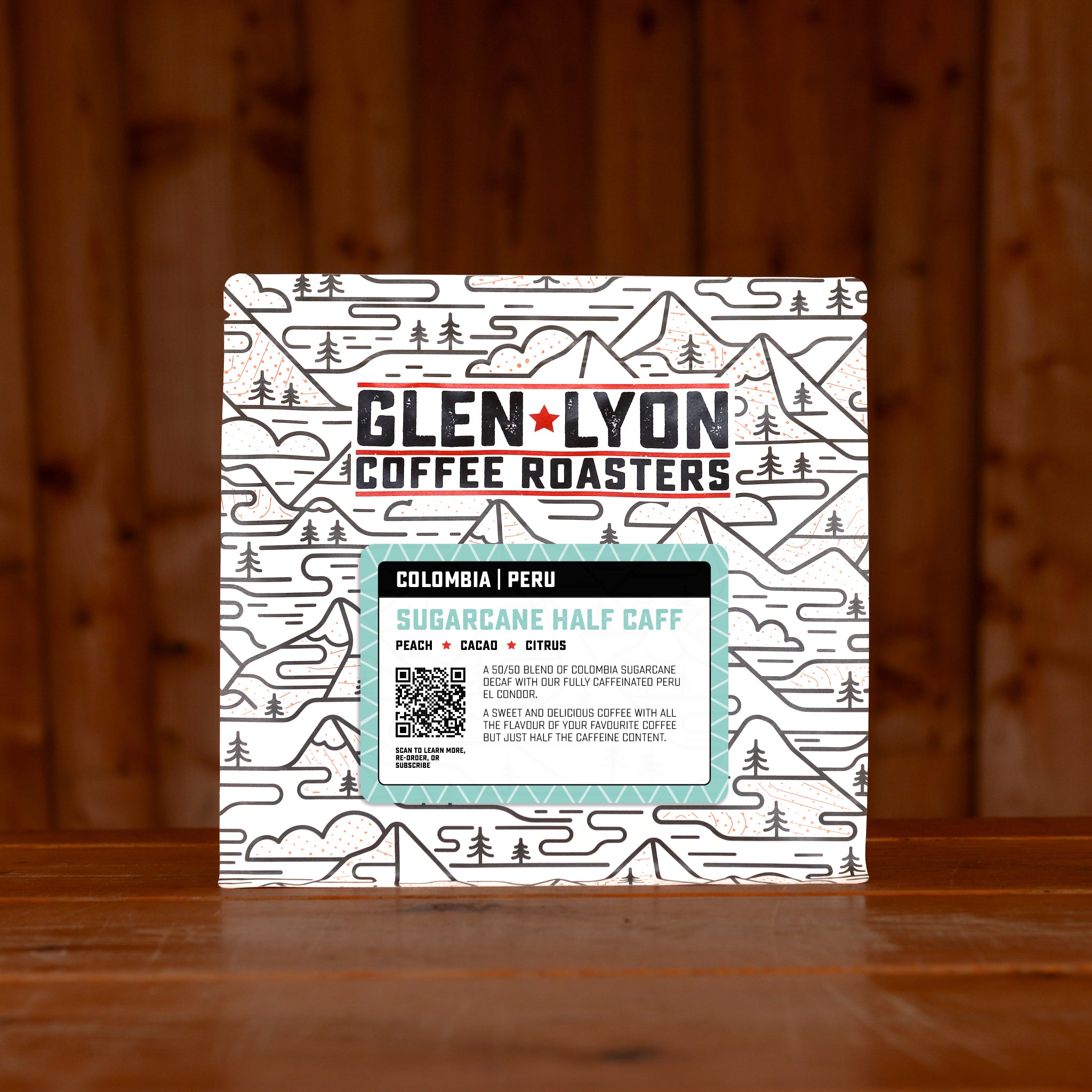 Turquoise Sugarcane Half Caff information sticker on a Glen Lyon branded coffee bag, sitting on a wooden table with a wood panel background.