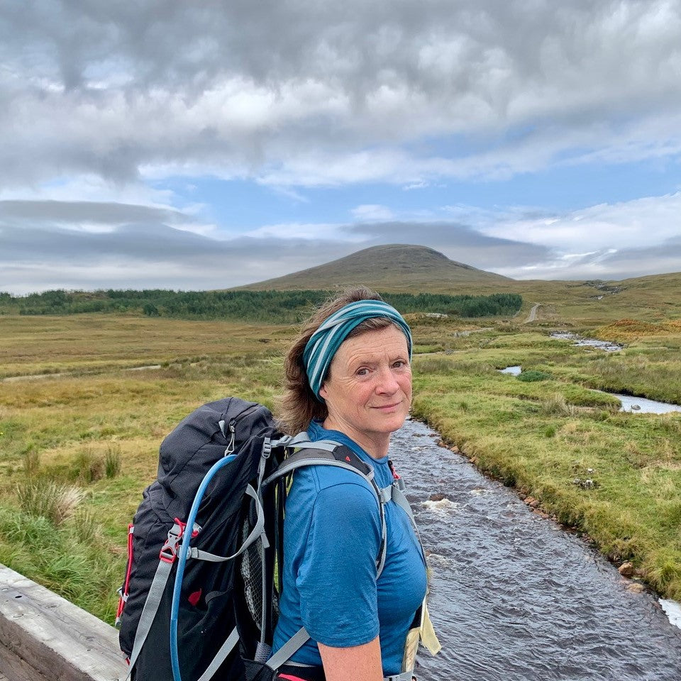 Writer Linda Cracknell looks at the camera with a wild Scottish landscape behind