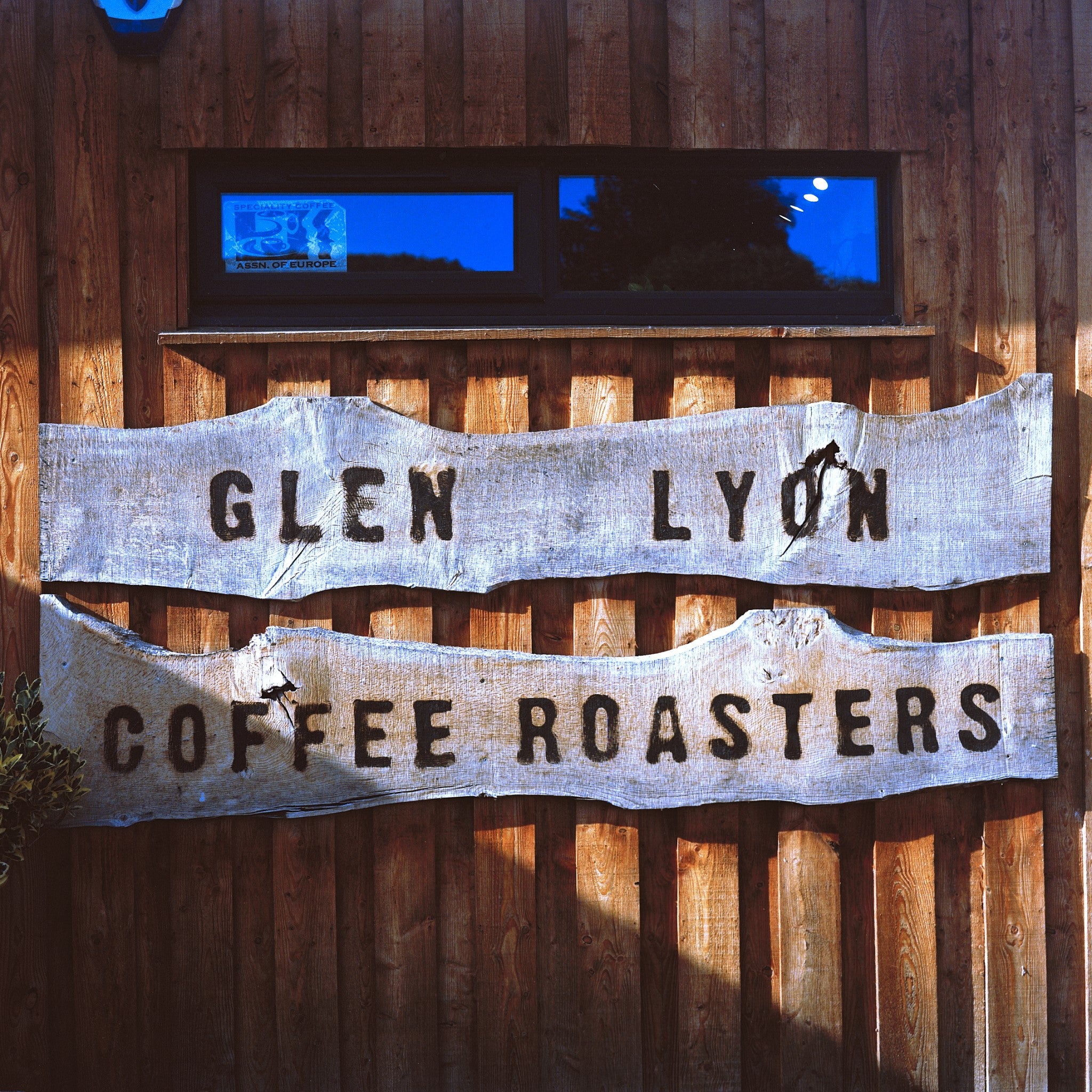 Image of wooden Glen Lyon Coffee Roasters sign hanging on the front of the roastery cafe