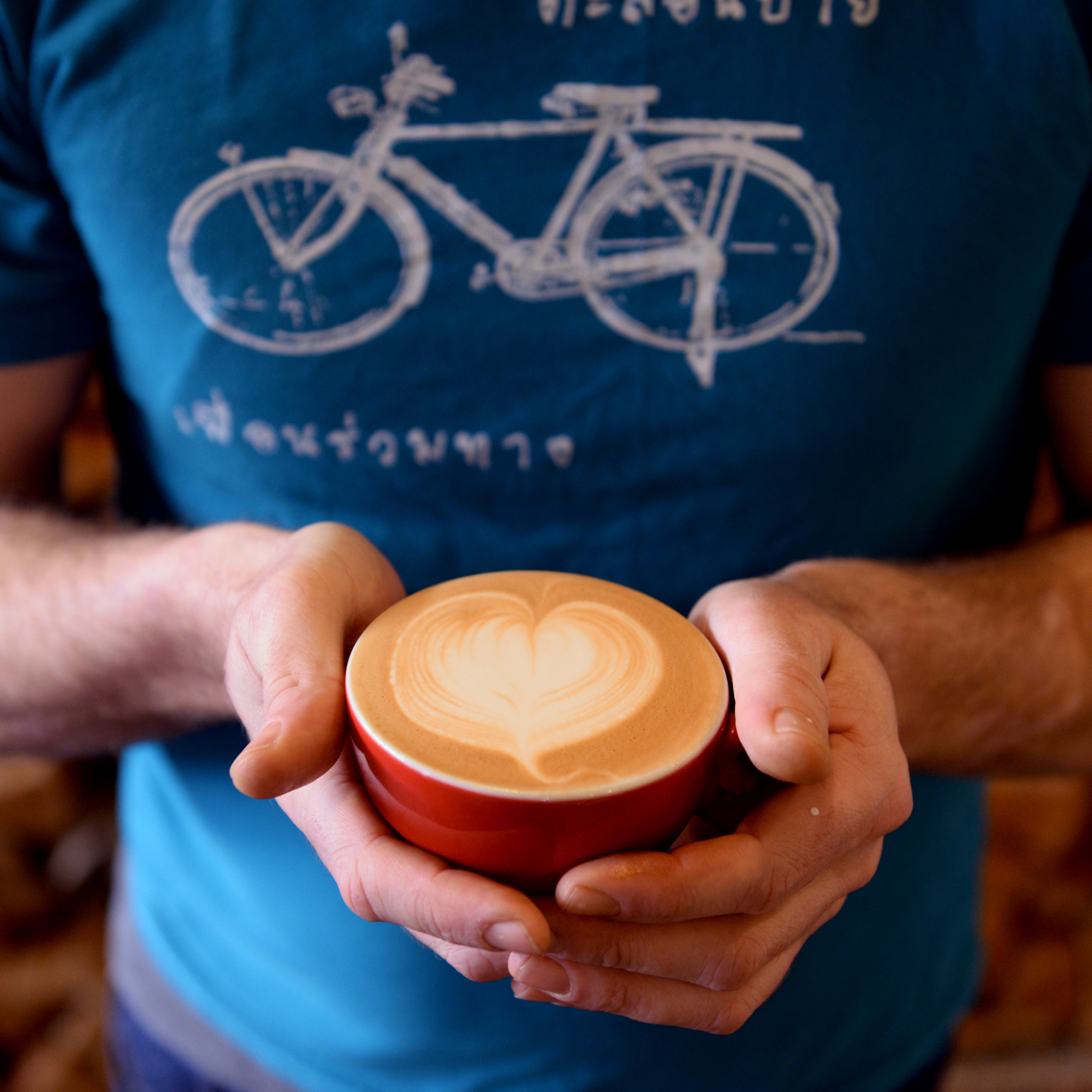 Two hands holding a coffee cup with latte art