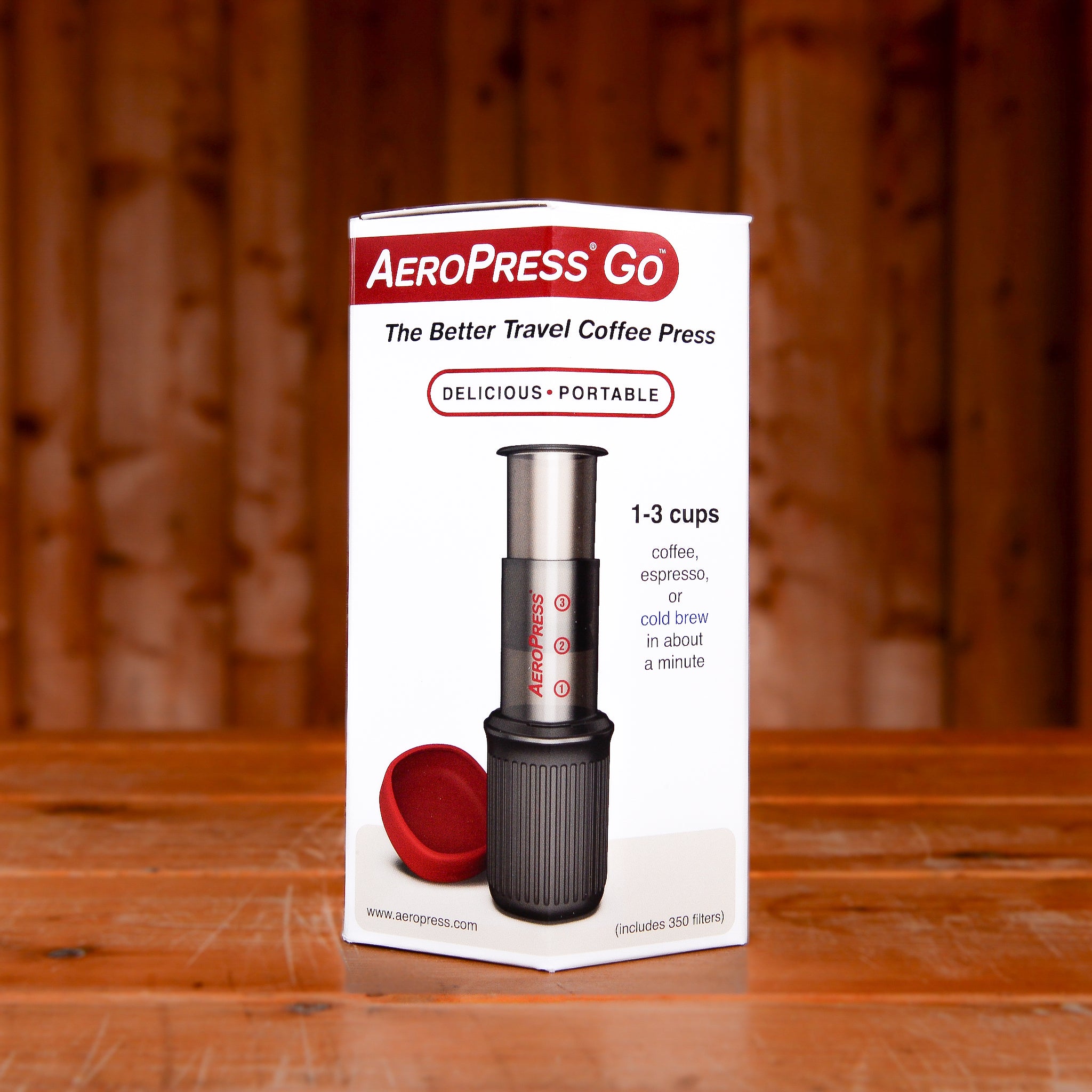 An AeroPress Go speciality coffee brewer in its white box on a wooden table