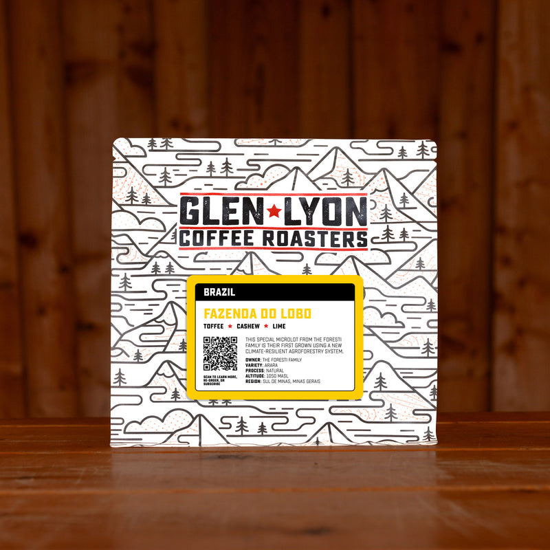 A 250g bag of Fazenda do Lobo from Glen Lyon Coffee Roasters coffee sits on a wooden table with a slatted wood background.