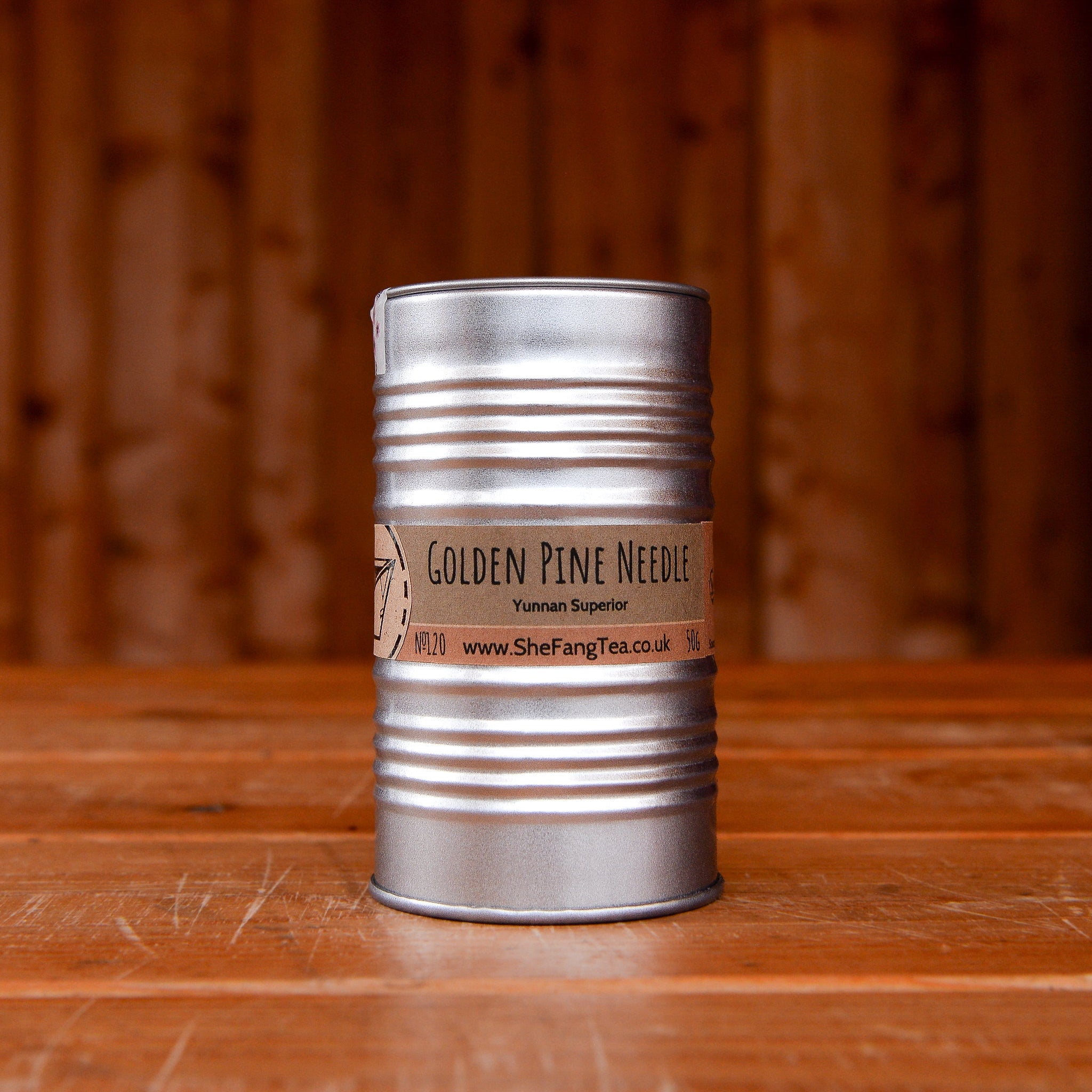 Golden Pine Needle tea in a tin can on a wooden table