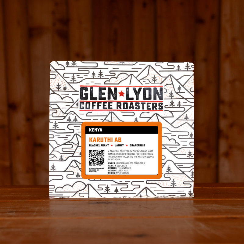 A 250g bag of Karuthi AB from Glen Lyon Coffee Roasters coffee sits on a wooden table with a slatted wood background.