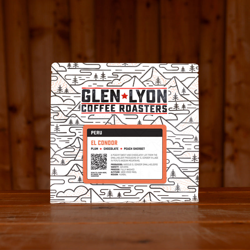 A 250g bag of El Condor from Glen Lyon Coffee Roasters coffee sits on a wooden table with a slatted wood background.