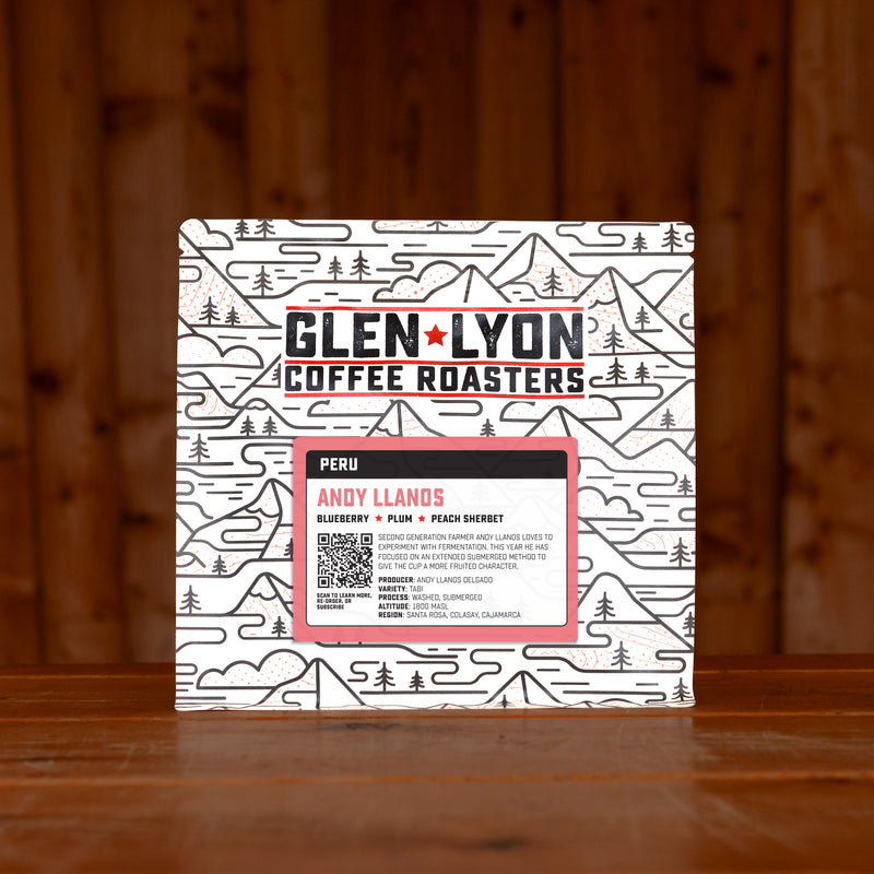 A 250g bag of Andy Llanos from Glen Lyon Coffee Roasters coffee sits on a wooden table with a slatted wood background.