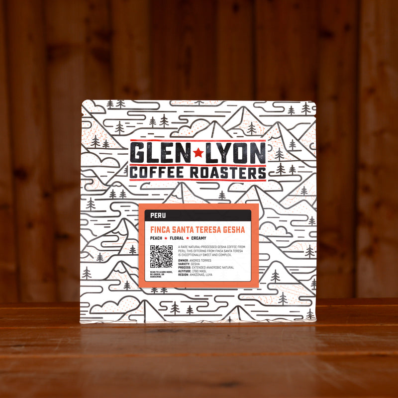 A 250g bag of Santa Teresa from Glen Lyon Coffee Roasters coffee sits on a wooden table with a slatted wood background.