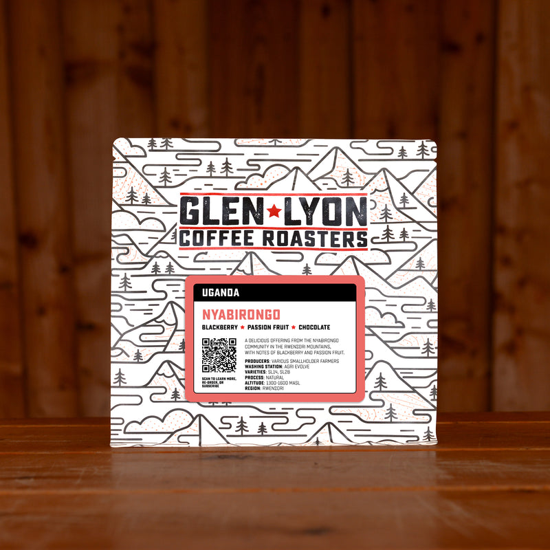 A 250g bag of Nyabirongo from Glen Lyon Coffee Roasters coffee sits on a wooden table with a slatted wood background.
