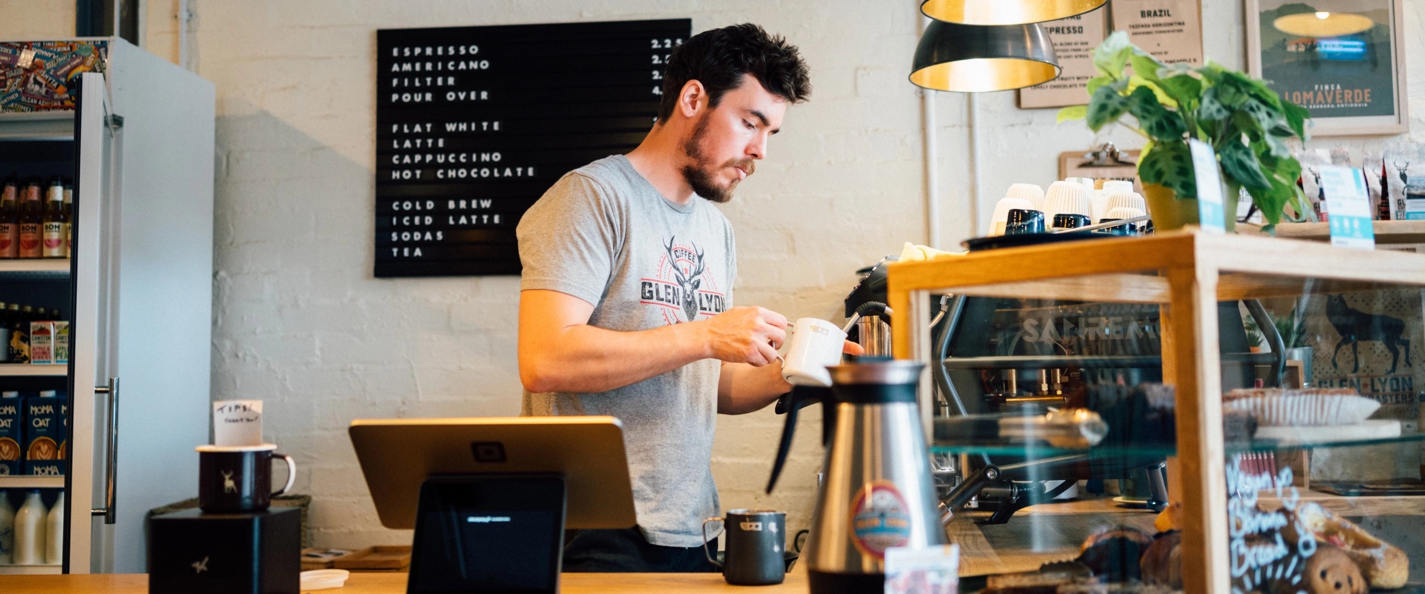 A banner image of a barista working behind the bar at the Glen Lyon Coffee speciality roastery cafe