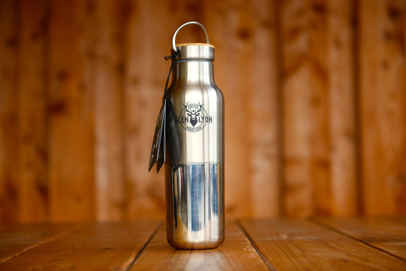 A stainless steel insulated flask with laser engraved Glen Lyon Coffee Roasters logo sits on a wooden table.