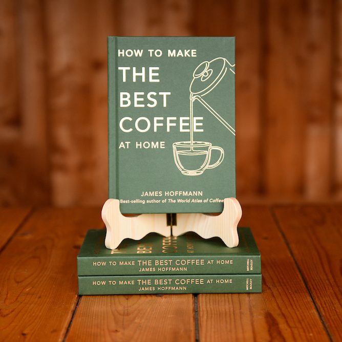 The book How To Make the Best Coffee At Home by James Hoffmann displayed on a book stand on a wooden table