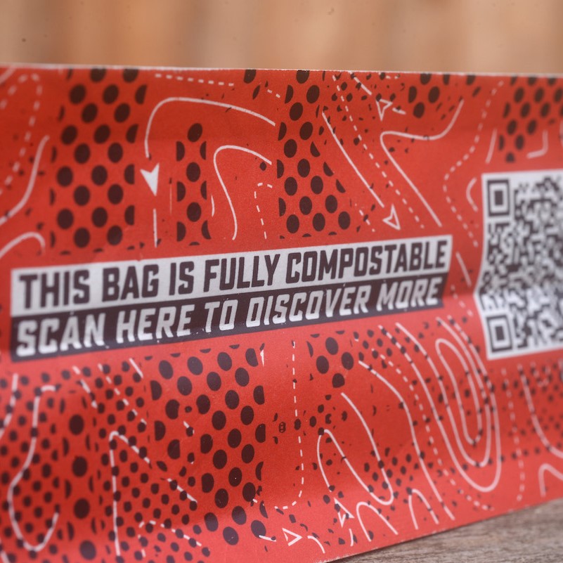 Closeup of the bottom of a Glen Lyon Coffee compostable bag, showing QR code and text that reads "This bag is fully compostable, scan here to learn more"