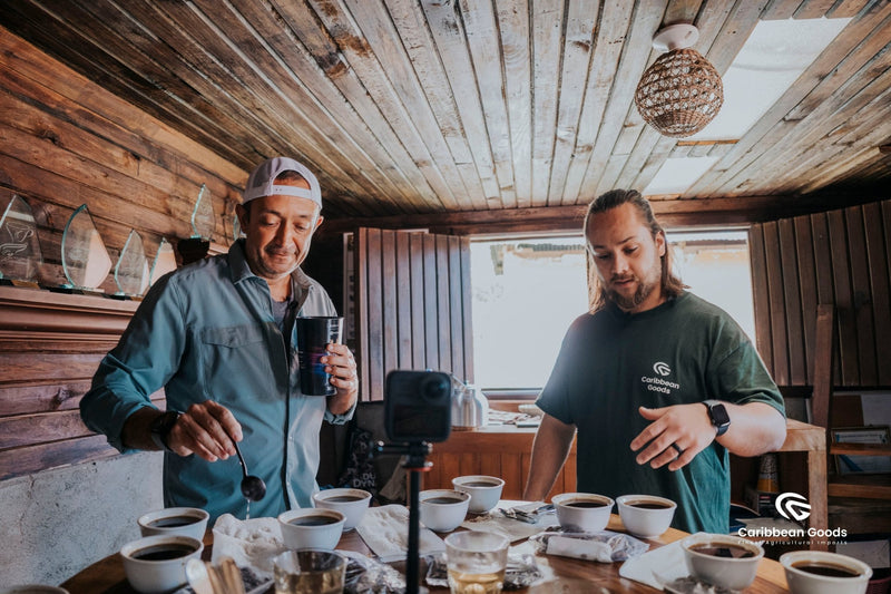 Javier and another man stand in a room in the middle of a cupping. Various glass awards are displayed proudly on the wall.