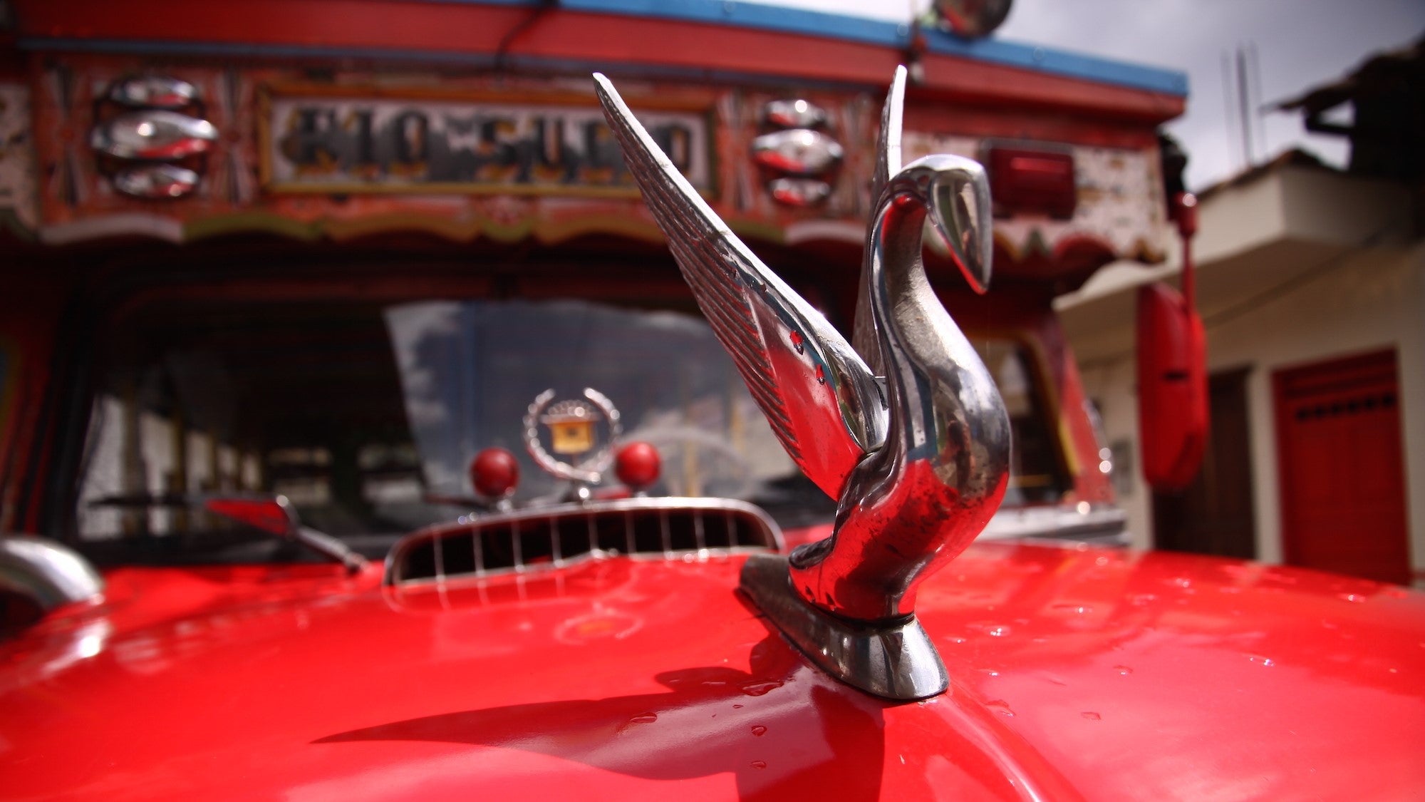 Close up of a red vintage car's hood ornament in Colombia